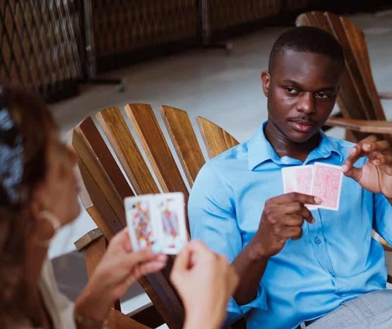 Pot odds in poker with man in blue button up shirt holding playing cards